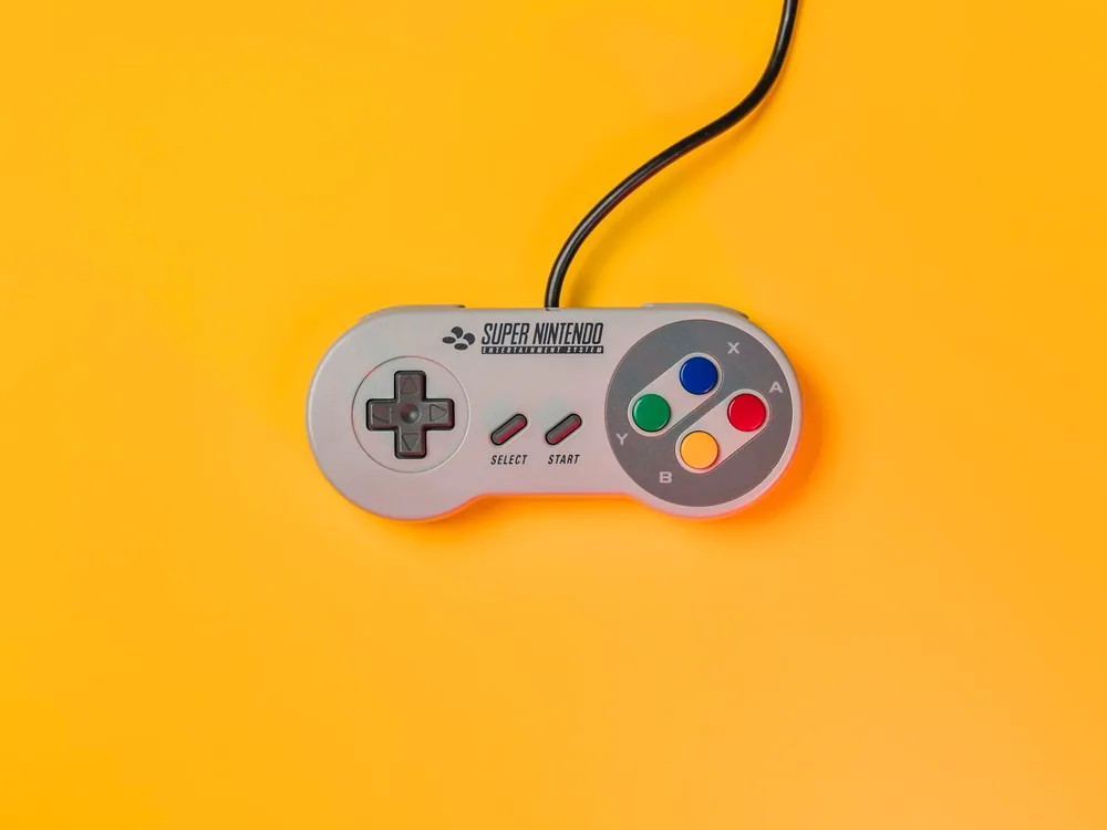 Controller da gioco su fondo ambra, sotto luce da studio